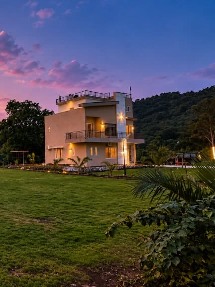The villa at dusk, with the lawn in the foreground.